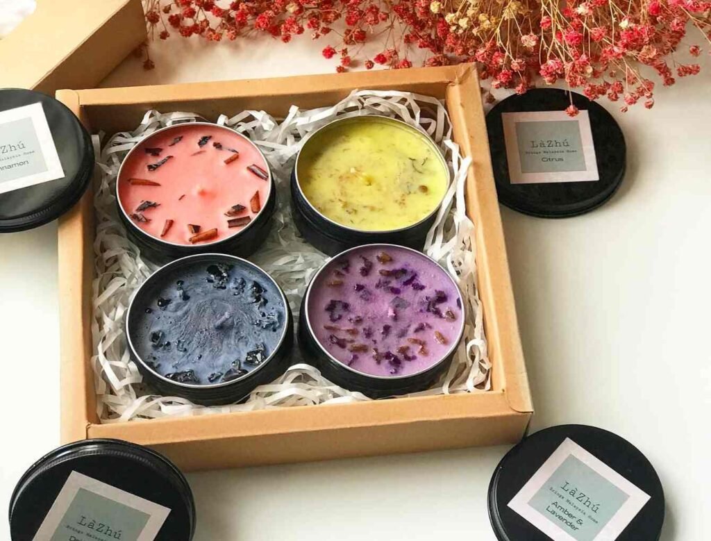 Soy wax candles with dry flowers in tin: Cinnamon (Pink), Citrus (Yellow), Amber & Lavender (Purple) and Driftwood (Blue); available at Haru To Natsu, Tokyo Street Pavilion Kuala Lumpur.