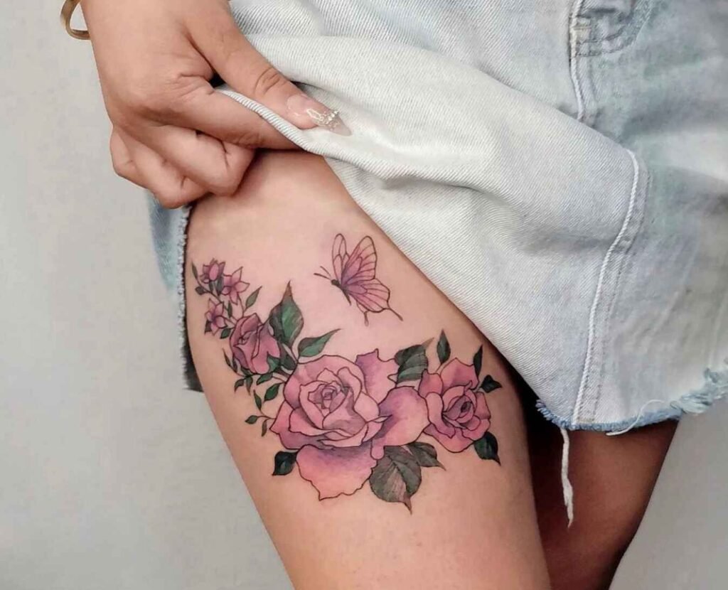 A girl pulls up her dress, revealing a discreet, beautifully designed tattoo of roses and a butterfly on the right thigh by Spec Body Art, Tokyo Street Pavilion Kuala Lumpur