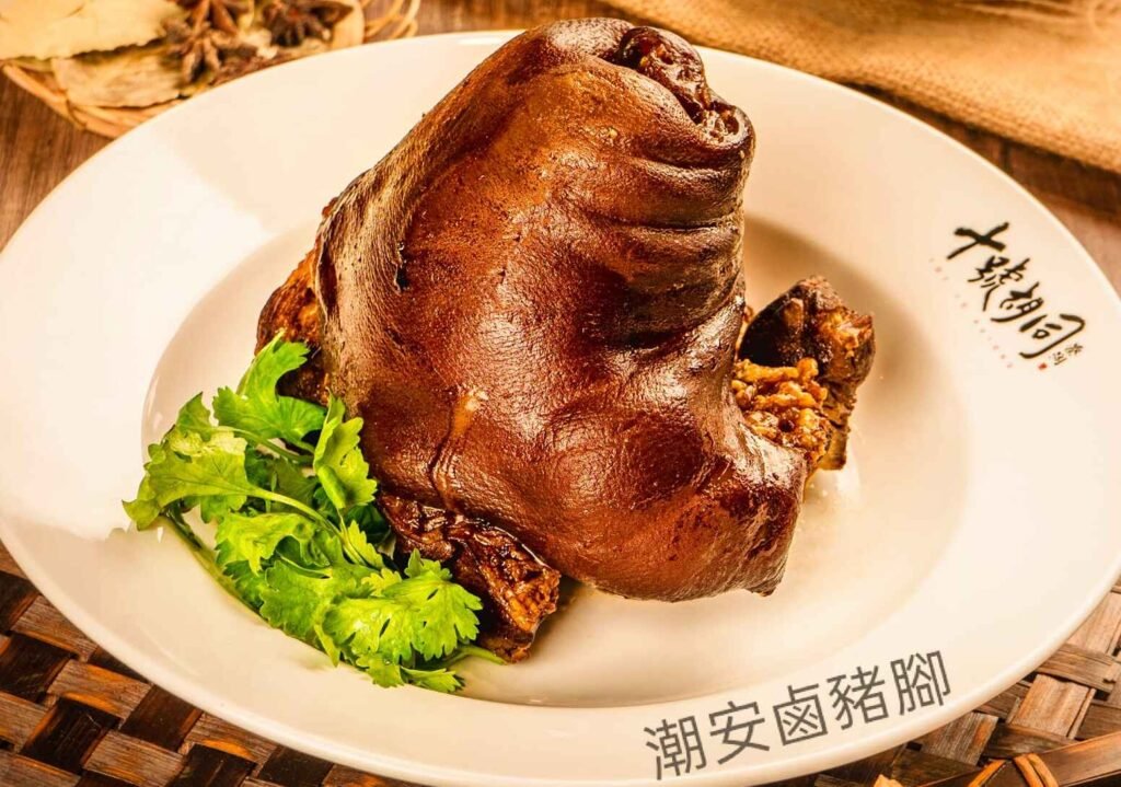 Teochew Braised Pork Knuckle, also known as "lu zhu shou" (卤猪手) in Chinese, is a popular dish featuring pork knuckle simmered in a sweet and savory, aromatic braising sauce made with ingredients like ginger, garlic, spring onions, soy sauce, cinnamon, star anise, dried chilies, and rock sugar. A signature dish at Hao Ji Braised Meats, Lot 10 Hutong Food Court, the dish is characterized by its tender, melt-in-your-mouth texture, rich, dark color.