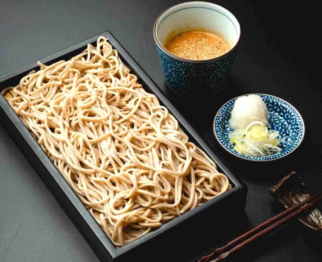 Homemade Cold Soba noodles made from Hokkaido buckwheat flour, perfectly arranged on a traditional bamboo mat in a rectangular, lacquered box (jubako), with a small bowl of Miso dipping sauce (tsuyu) and garnishes like green onions and wasabi. A top rated seasonal dish at Mitsumori KL, The Table @ Isetan The Japan Store, Lot 10, Bukit Bintang, Kuala Lumpur.