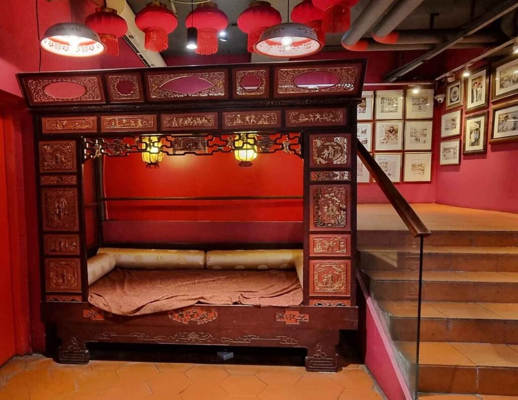 The antique Ming Dynasty-style marriage bed in Lot 10 Hutong Food Court features intricate carvings and ornate details, such as dragons, phoenixes, flowers, and auspicious symbols. Visitors enjoy sitting on it to snap Instaworthy photos.