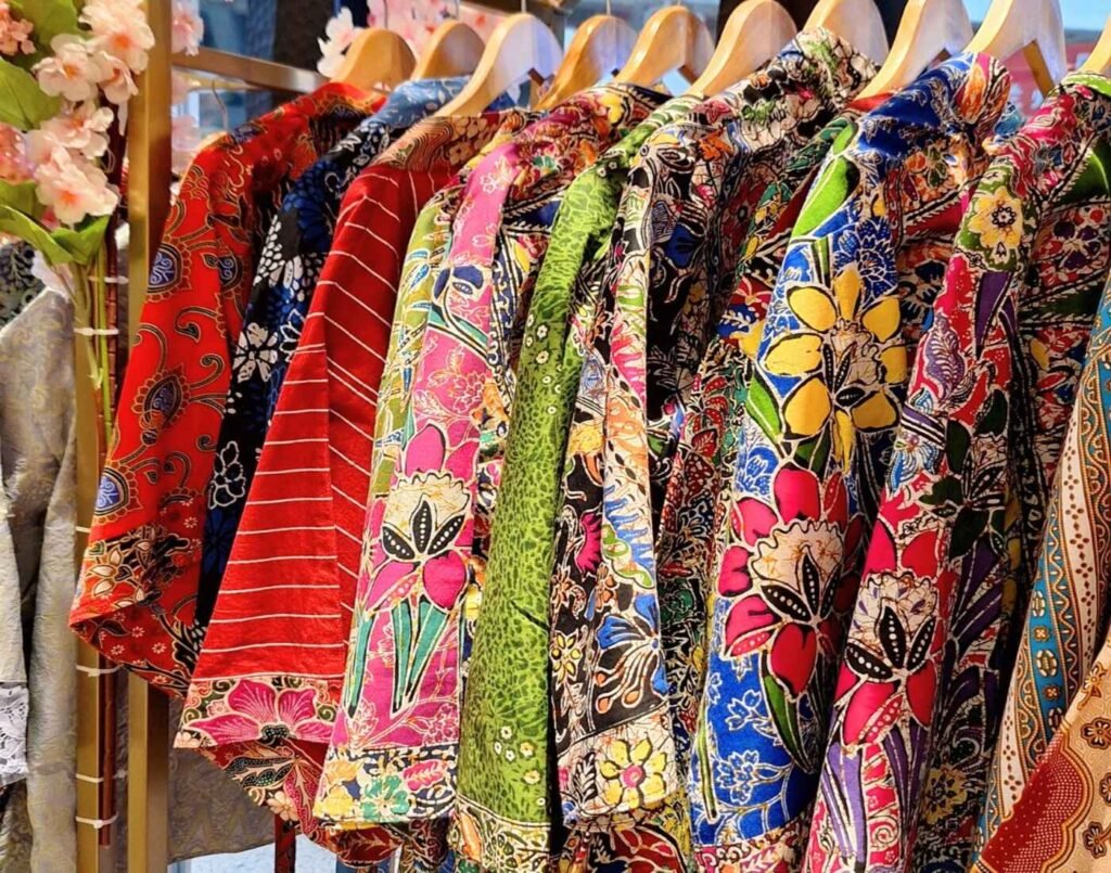 Colourful batik and songket baju kurung, kebaya and Japanese kimono on hangers at Hani Nazeera, a Malaysian fashion label blending heritage textiles with modern womenswear, located at The Design, Lower Ground Floor, Isetan The Japan Store Lot 10, Bukit Bintang, Kuala Lumpur.