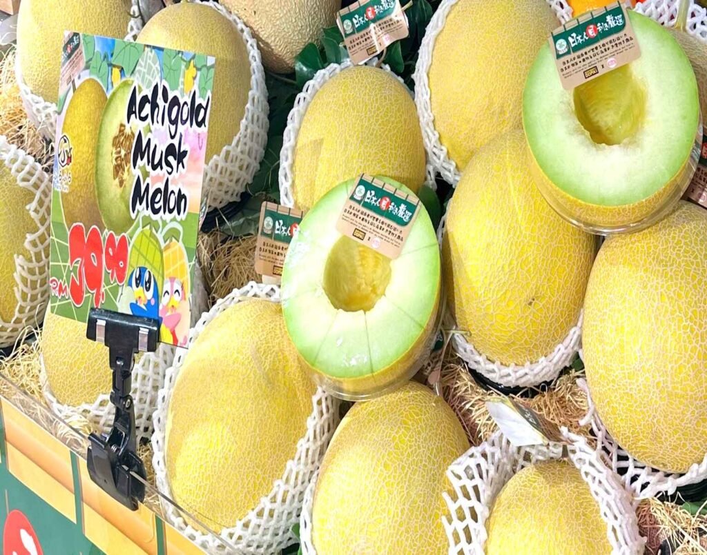 Premium Japanese Achi Gold Melons displayed in the Furu Furu premium fruits section at Jonetz By Don Don Donki Lot 10, a Japanese supermarket in Bukit Bintang, Kuala Lumpur. These golden muskmelons, also known as Mas Melon in Malaysia, are beautifully packaged and air-flown from Japan, known for their smooth rind, rich aroma, and exceptional sweetness.