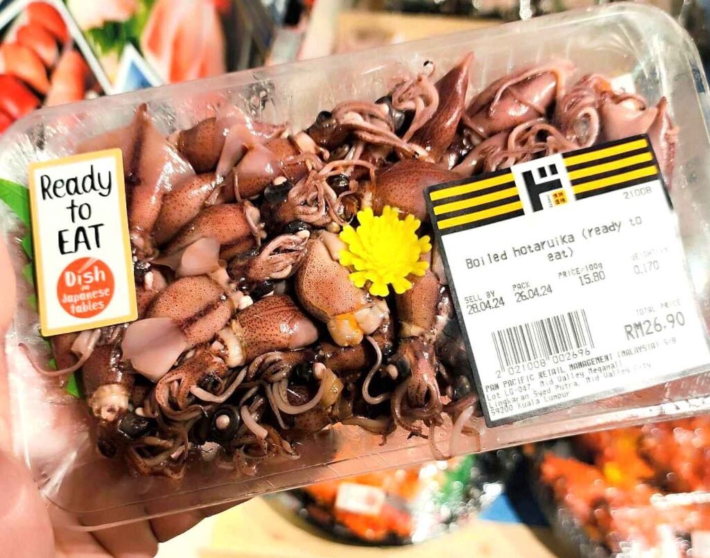 Pre-packaged boiled Hotaruika (firefly squid) with a “Ready to Eat” label, featuring small pinkish-brown squid (Japanese seafood delicacy) in the seafood section at Jonetz By Don Don Donki Lot 10, a Japanese supermarket in Bukit Bintang, Kuala Lumpur.