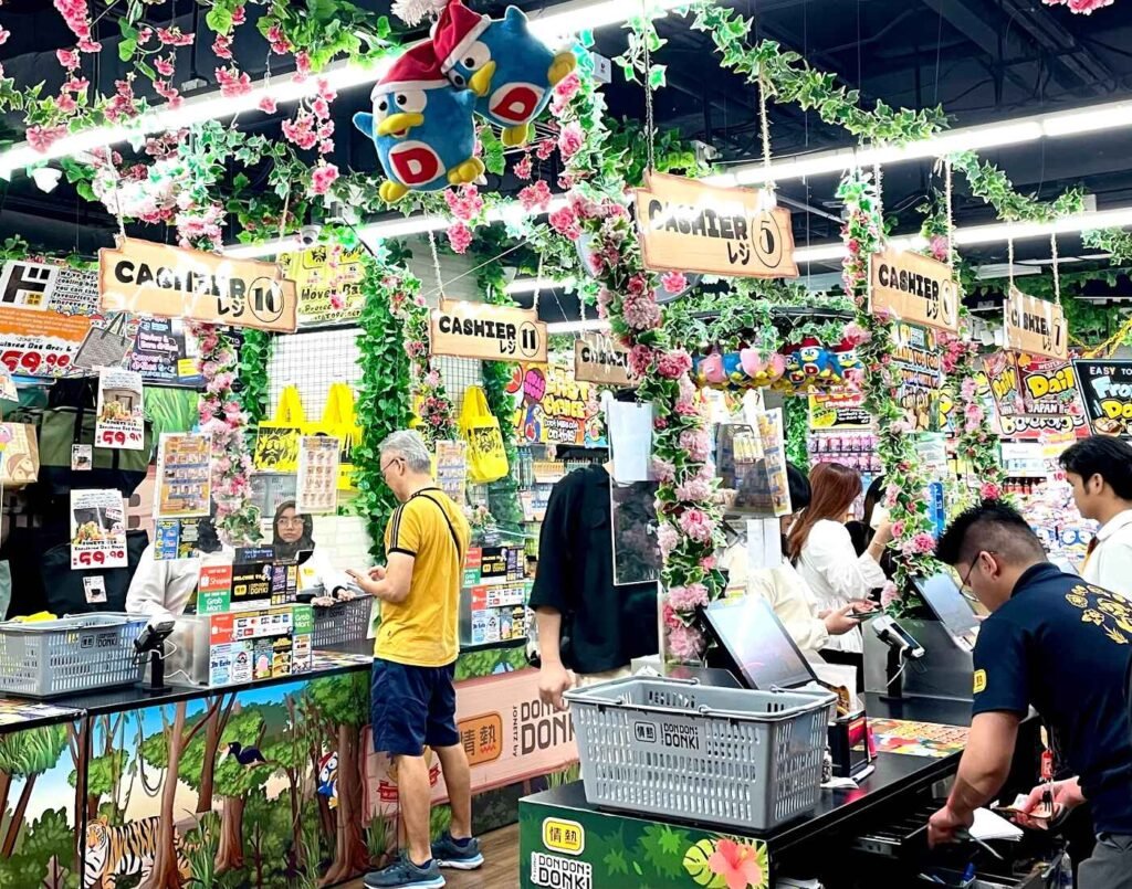 Cashier and checkout counters at Don Don Donki Lot 10 in Bukit Bintang, Kuala Lumpur with customers queuing under decorated signage and Japanese-themed displays.