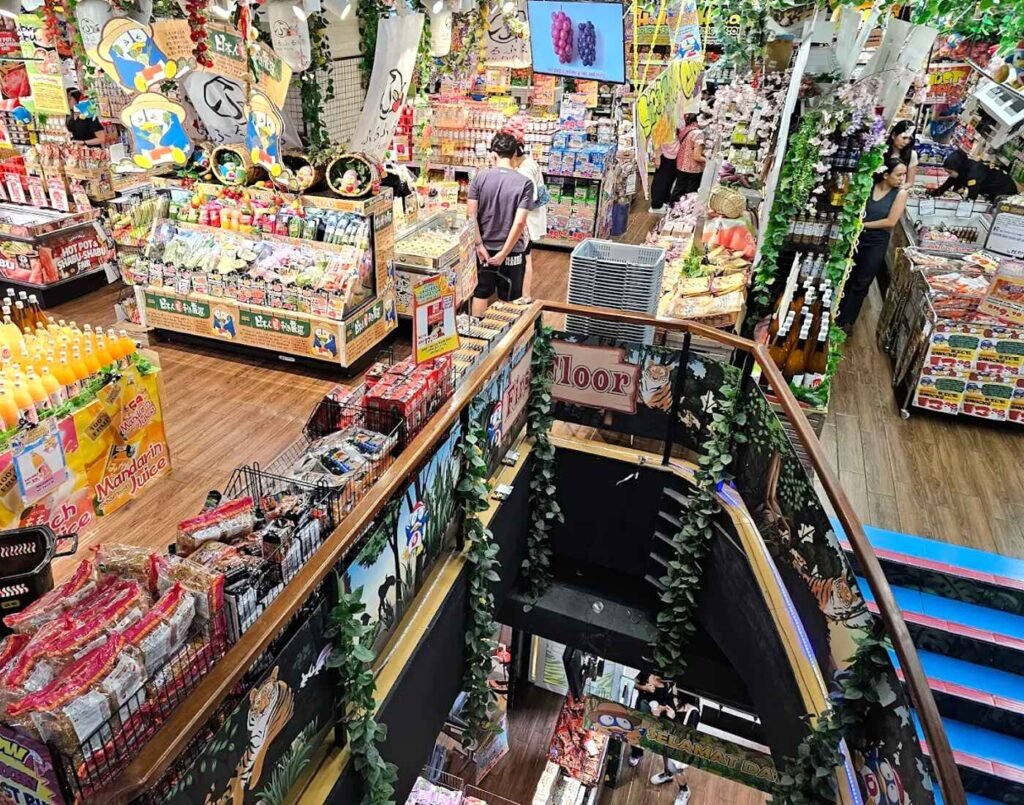 Multi-level interior view of Don Don Donki Lot 10 in Kuala Lumpur showing snack aisles, grocery sections, and interconnected floors from an upper level perspective.