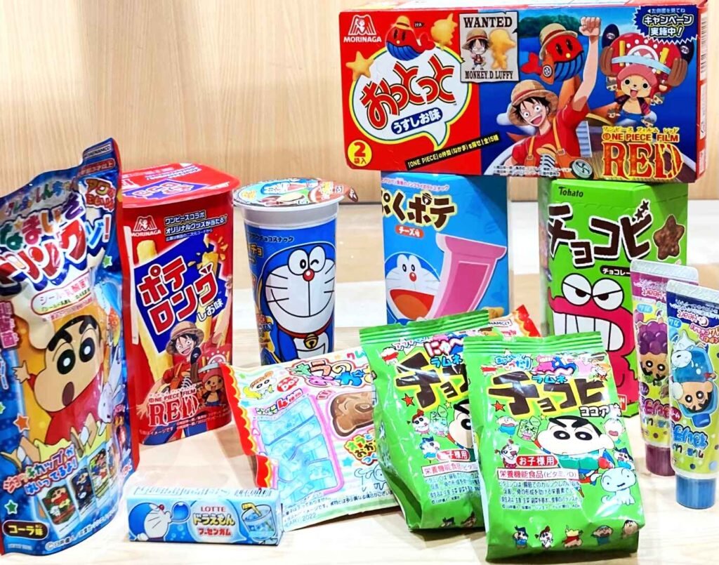 Assortment of Japanese anime character-themed snacks including Doraemon chips, Crayon Shin-chan Chocobi, and One Piece candy kits, available at Jonetz By Don Don Donki Lot 10, a Japanese supermarket in Bukit Bintang, Kuala Lumpur.