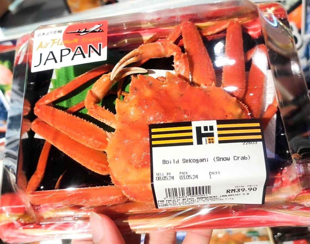 Close-up of a pre-packaged tray of whole, boiled seko gani (female Snow Crab), a rare winter delicacy from Japan known for its rich roe and sweet meat. Available in the chilled seafood section at Jonetz By Don Don Donki Lot 10, a Japanese supermarket in Bukit Bintang, Kuala Lumpur.