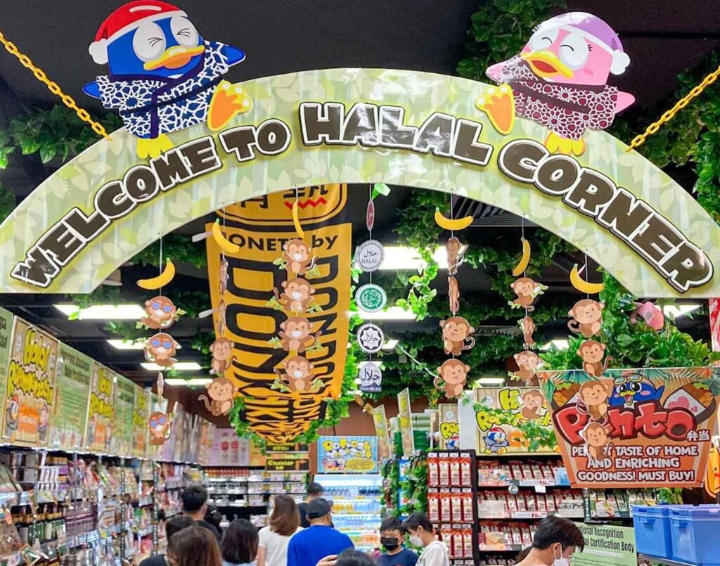The ‘WELCOME TO HALAL CORNER’ archway featuring Donki mascots and visible Halal logos (recognized by JAKIM), at the dedicated halal section featuring muslim-friendly products at Jonetz By Don Don Donki Lot 10, a Japanese supermarket in Bukit Bintang, Kuala Lumpur.