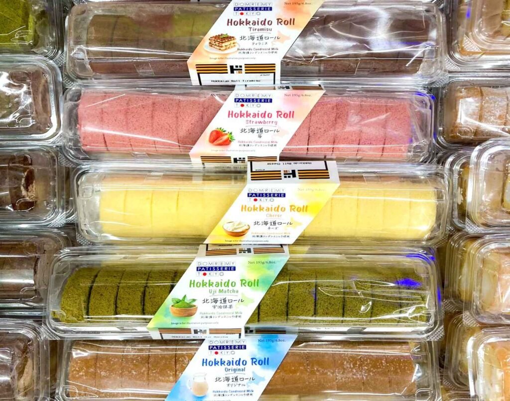 Colourful selection of Hokkaido Roll Cakes by Domremy Patisserie Kiyo, featuring flavours such as Tiramisu, Strawberry, Cheese, Uji Matcha, and Original Milk, neatly displayed in the chilled dessert section at Jonetz By Don Don Donki Lot 10, a Japanese supermarket in Bukit Bintang, Kuala Lumpur.