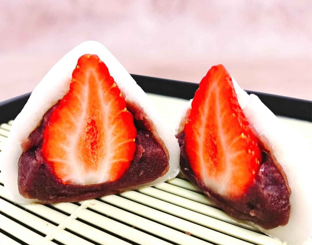 Fresh Ichigo Daifuku, a Japanese mochi dessert filled with sweet red bean paste and a whole ripe strawberry, cut open to reveal its vibrant filling. A seasonal wagashi favourite available at Jonetz By Don Don Donki Lot 10, a Japanese supermarket in Bukit Bintang, Kuala Lumpur.