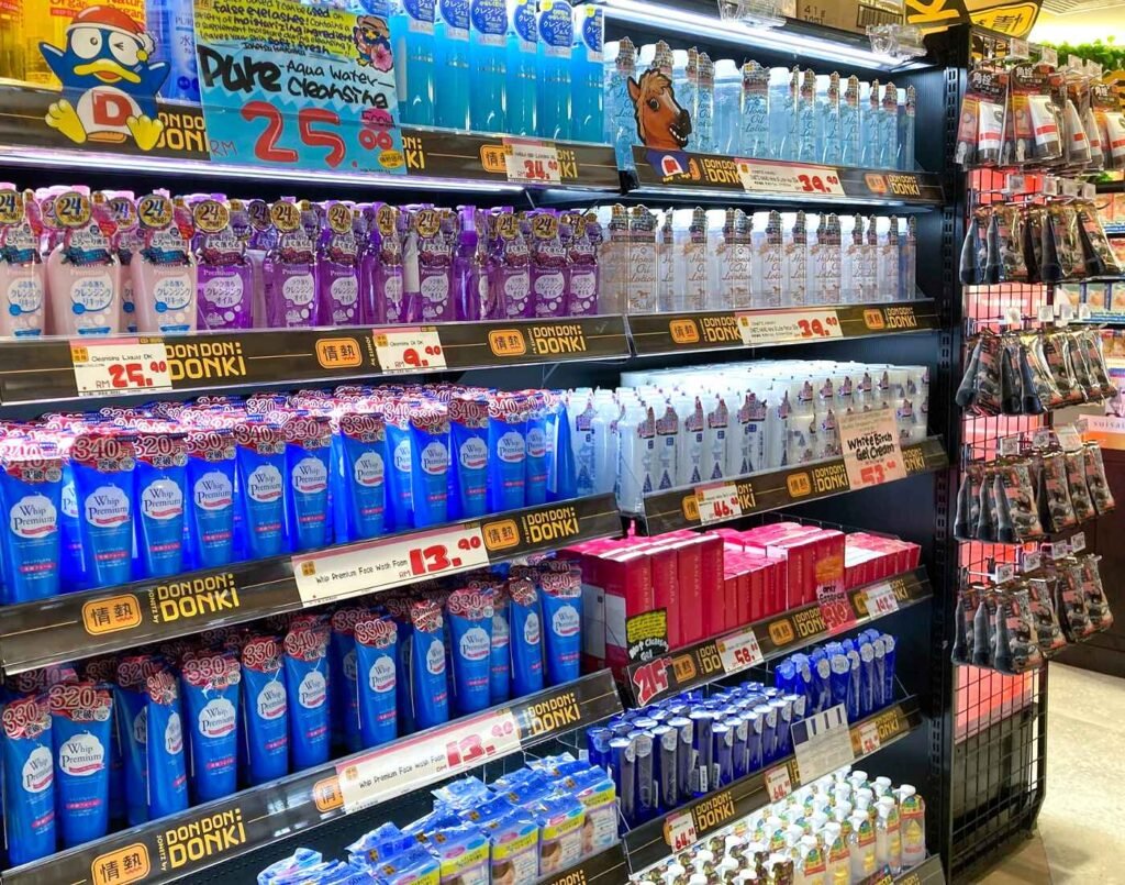 Shelves of Japanese facial cleansers and skincare staples including Senka Perfect Whip foam cleansers, Hada Labo Gokujyun lotions, and Softymo cleansing products at Don Don Donki Lot 10 in Bukit Bintang, Kuala Lumpur.