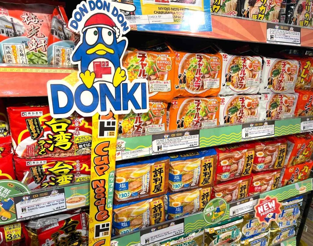 Shelves filled with Japanese instant ramen packets from brands such as Myojo, Maruchan, and Sugakiya, including popular lines like Charumera and Hyoutenya, displayed at Don Don Donki Lot 10 in Bukit Bintang, Kuala Lumpur.