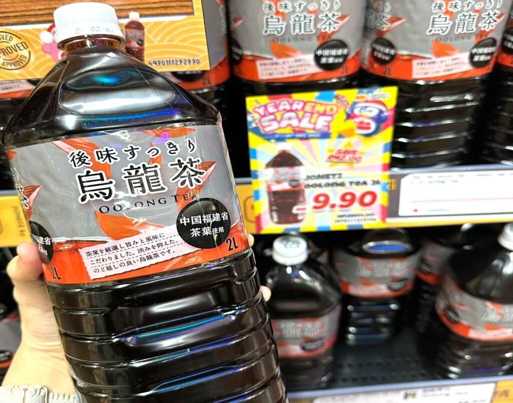 A transparent plastic 2-liter bottle of Japanese Oolong Tea, showing the unsweetened dark brown tea made with tea leaves from Fujian Province, China and the Jonetsu Kakaku label with ‘refreshing aftertaste’ in Japanese text. Available at Jonetz By Don Don Donki Lot 10, a Japanese supermarket in Bukit Bintang, Kuala Lumpur.