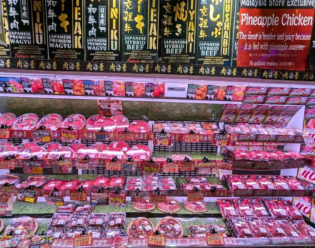 Display of chilled, pre-packaged premium Japanese Wagyu including Kyouyasu Wagyu Kiriotoshi, Kagoshima Wagyu and the exclusive Pineapple Chicken (seasoned with pineapple enzyme) for yakiniku, sukiyaki and shabu-shabu in the meat section at Jonetz By Don Don Donki Lot 10, a Japanese supermarket in Bukit Bintang, Kuala Lumpur.