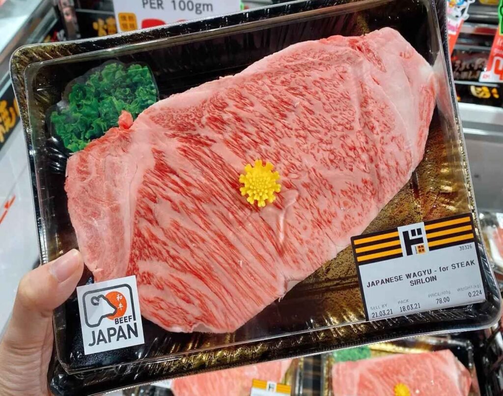 A vacuum-sealed pack of premium Japanese Wagyu Sirloin Steak for steak, showing intense marbling and the "Beef Japan" authenticity seal. Available at the fresh meat section of Jonetz By Don Don Donki Lot 10, a Japanese supermarket in Bukit Bintang, Kuala Lumpur.