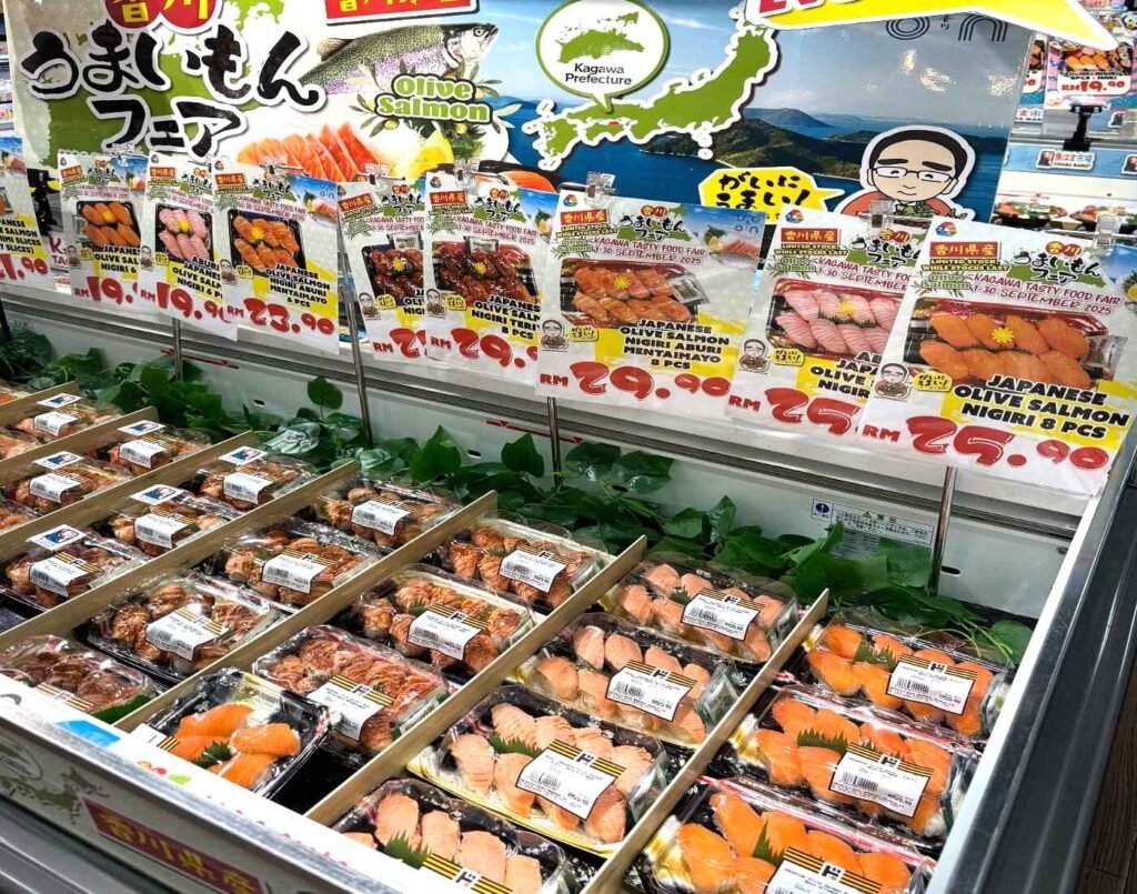Refrigerated display promoting a seasonal ‘Kagawa Tasty Food Fair’ featuring chilled packs of Japanese Olive Salmon nigiri and aburi sushi sets at Jonetz By Don Don Donki Lot 10, a Japanese supermarket in Bukit Bintang, Kuala Lumpur.