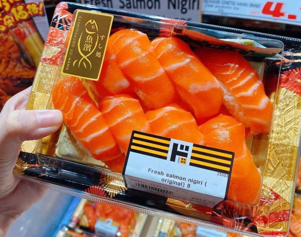 A pre-packaged tray of eight pieces of Fresh Salmon Nigiri from UOHAMA brand, featuring bright orange slices of salmon that highlight its freshness and premium quality. Available in the chilled seafood section at Jonetz By Don Don Donki Lot 10, a Japanese supermarket in Bukit Bintang, Kuala Lumpur.
