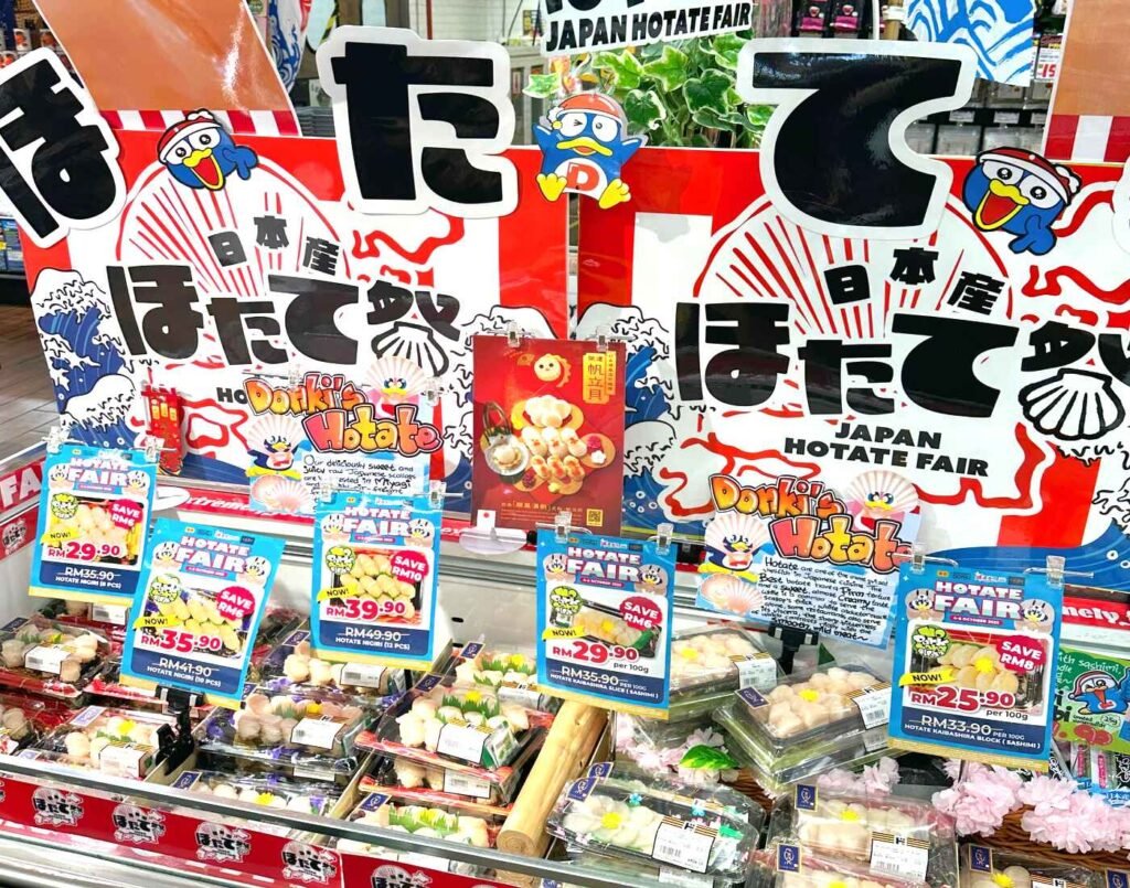Refrigerated display counter featuring a seasonal ‘Japan Hotate Fair’ promotion with discounted packs of fresh premium Hokkaido scallops (hotate) at the seafood section of Jonetz By Don Don Donki Lot 10, a Japanese supermarket in Bukit Bintang, Kuala Lumpur.